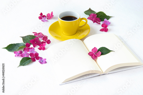 コーヒーと見開きの本とマゼンタの紫陽花のデザイン