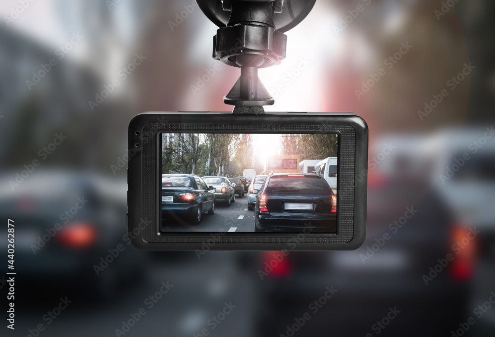 Modern dashboard camera mounted in car, view of road during driving