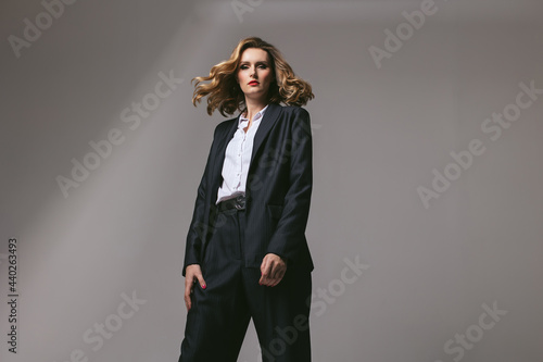 Stylish business successful confident woman in black work suit. Businesswoman in an oversized jacket looking forward. Goal setting. headway ahead . Work dress code. Men's suit. Red lipstick. feminist