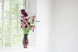 iris flowers in glass vase on white old windowsill