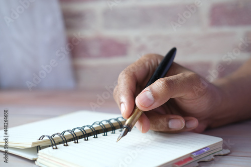 Close up of man hand writing on notepad.