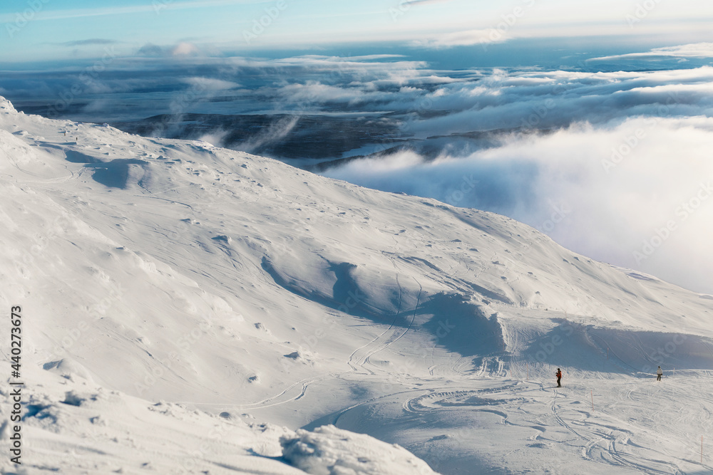 Snowy mountain slope above clouds Snowy mountain slope above clouds