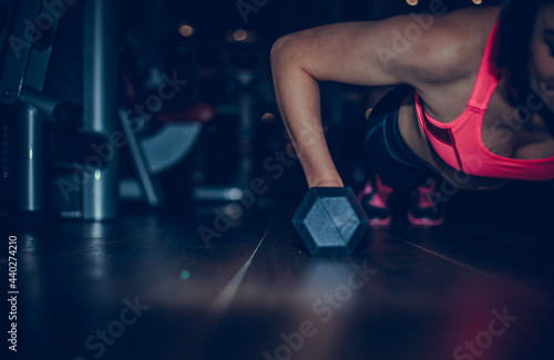 Sport and recreation concept. Sporty woman hands with black dumbbells. © Inception