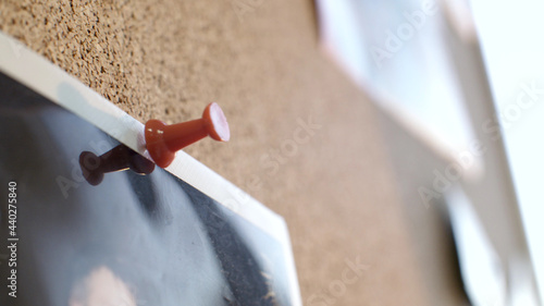 Canvas Print Close up of photo pinned to corkboard with red pin