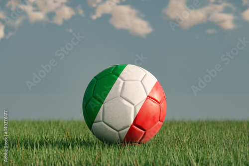 Italian football with the national colors of Italy on a green meadow. Leather in slightly used look. Background blue with clouds. 3D illustration.