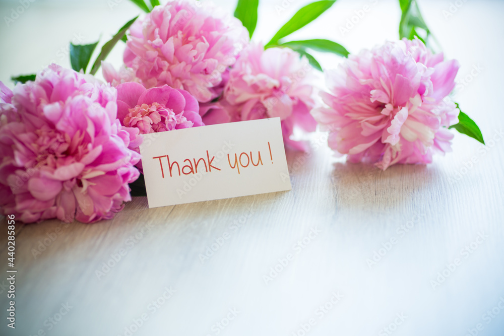 several branches of blooming pink peonies on a wooden table several branches of blooming pink peonies on a wooden table