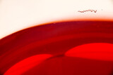 Red wine glass with a small group of bubbles on the edge of the glass.