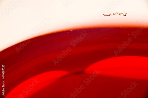 Red wine glass with a small group of bubbles on the edge of the glass.