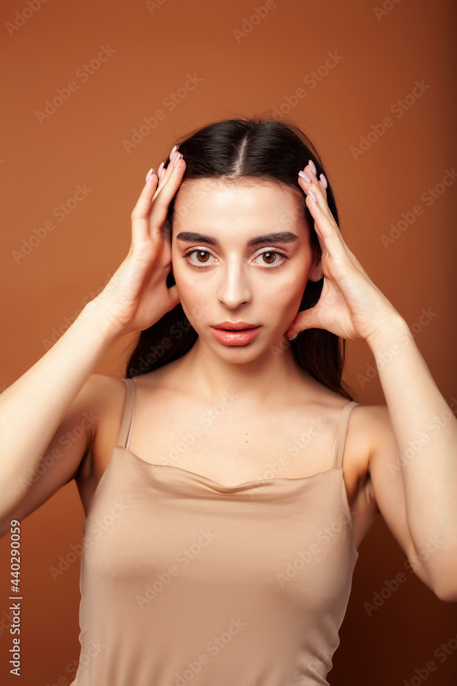 Obraz premium cute happy young indian woman posing cheerful on brown background in studio close up smiling, fashion beauty