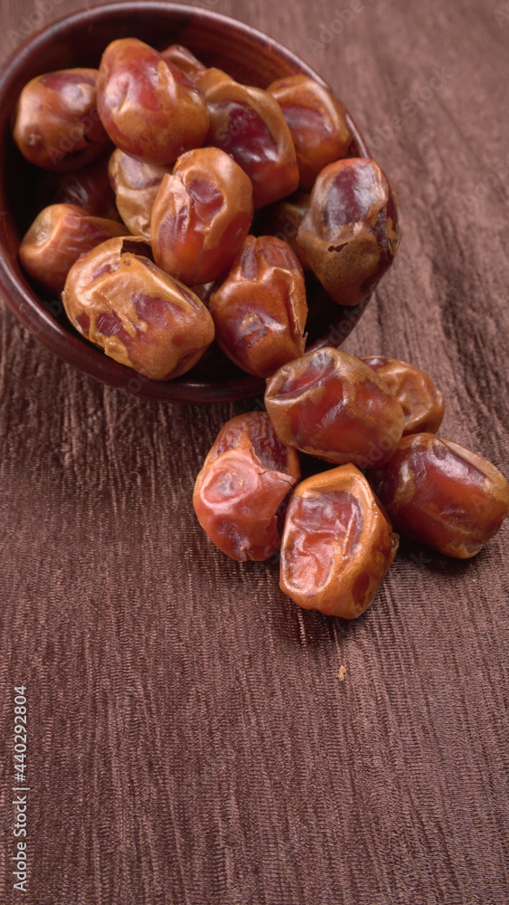 Obraz premium Dates in wooden bowl on background. dried dates fruit.