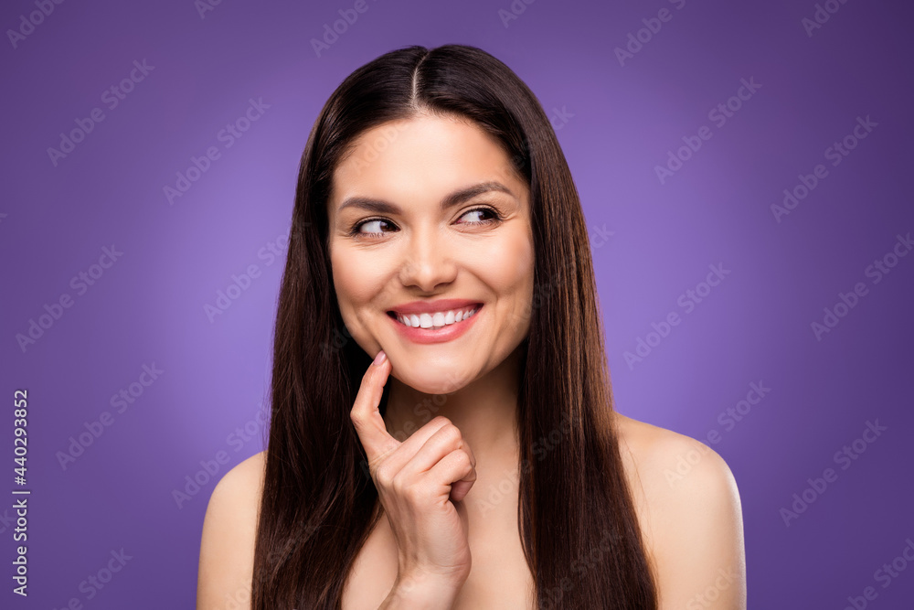 Photo of pretty dreamy young lady wear nothing arm chin looking empty space smiling isolated purple color background Photo of pretty dreamy young lady wear nothing arm chin looking empty space smiling isolated purple color background