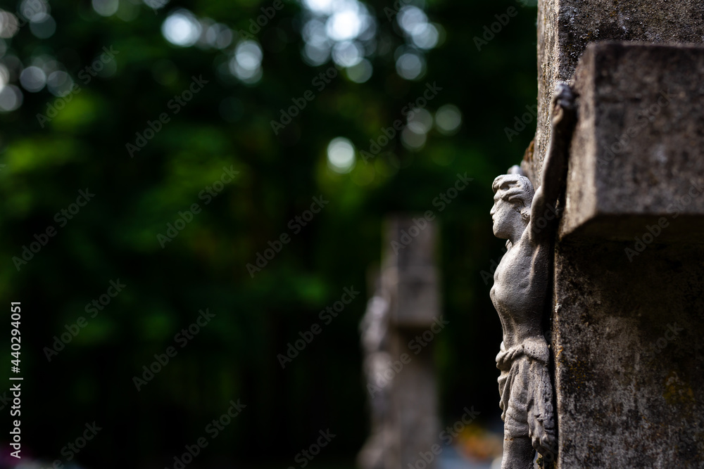 Jesus figurine on the cemetery cross. Picture taken in a soft light, shaded place. Jesus figurine on the cemetery cross. Picture taken in a soft light, shaded place.