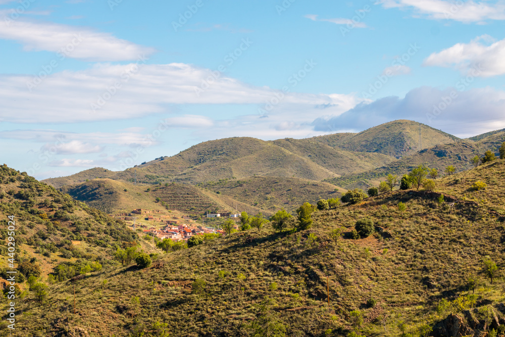 Little green hill captured during a sunny day with some white clouds in a blue sky. Little green hill captured during a sunny day with some white clouds in a blue sky.