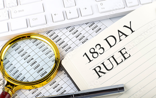 183 DAY RULE text on notebook with chart  magnifier keyboard and pen