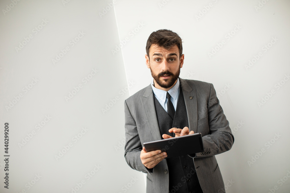 Young modern businessman using digital tablet in the office