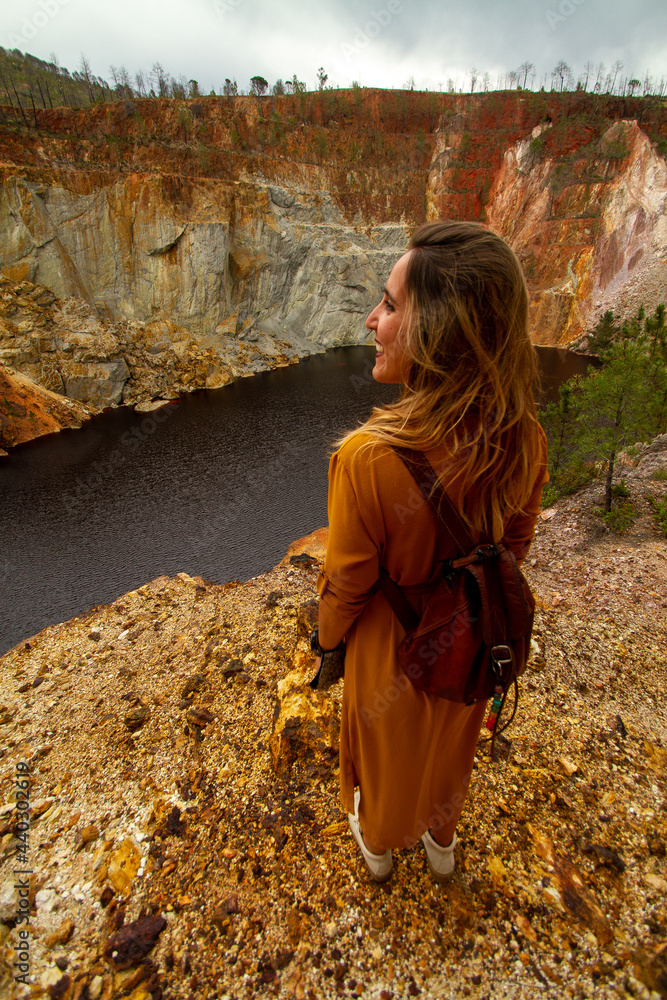 young woman with a yellow dress and a leather backpack in a lake at desert young woman with a yellow dress and a leather backpack in a lake at desert