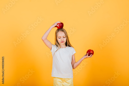 Beautiful blonde girl with red apple in studio