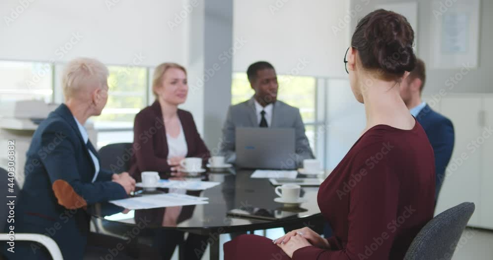 Portrait of attractive businesswoman looking at camera sitting at conference room with colleagues. Portrait of attractive businesswoman looking at camera sitting at conference room with colleagues.