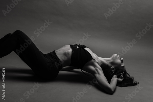 Posing fitness seductive woman isolated on grey background