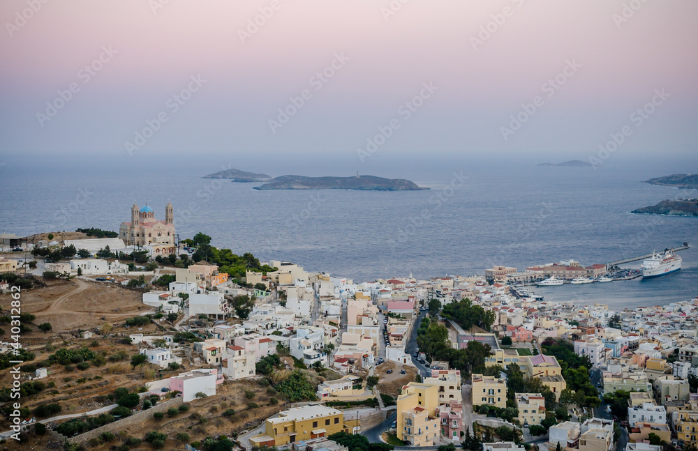 Panoramic View of Ermoupolis City in Syros Island, Greece at Sunset. Nice Seascape and Greek Horizon View of Aegean Sea. Traditional White Houses, Villas, Church and Port. 