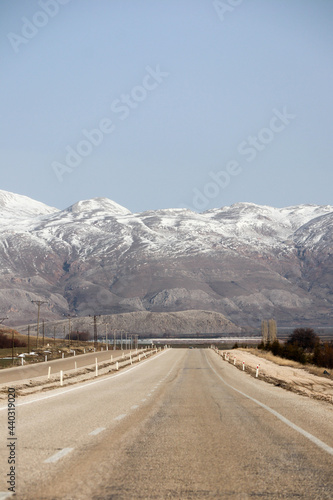 scenic asphalt road highway in the spring mountains with snow peaks on the background, Turkey