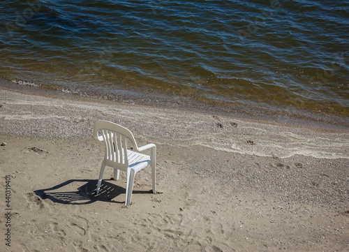 Lone plastic chair on the beach on Lake Winnipeg, Canada © luminatephotos