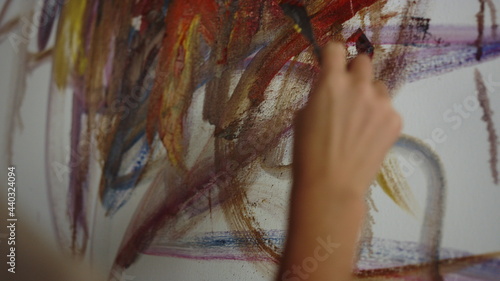 Unrecognizable woman drawing in studio. Painter working on artwork indoors.