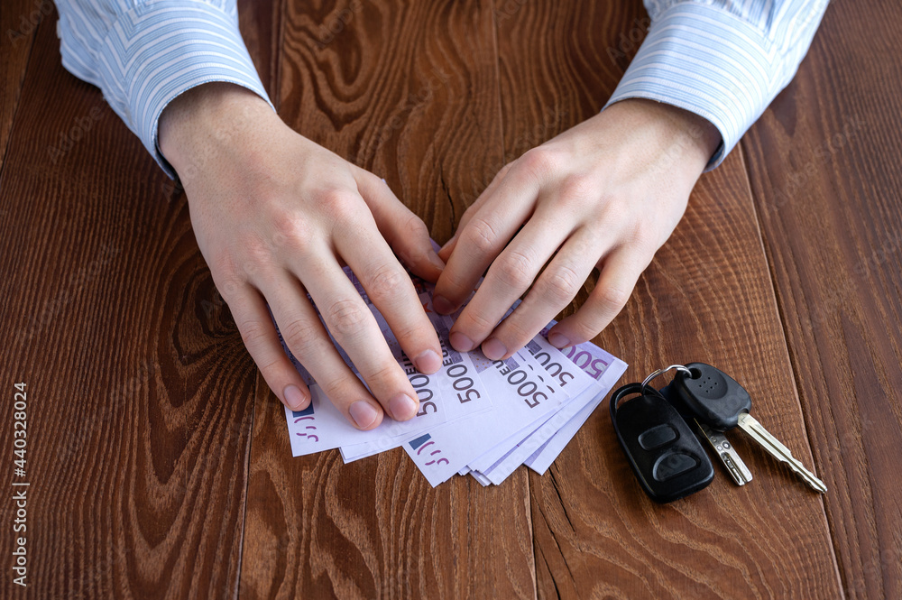 Human hands, money, and car keys. Buying and selling cars Human hands, money, and car keys. Buying and selling cars