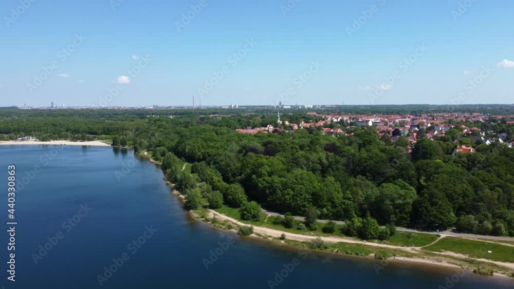 Drone flight with panoramic view of a lake and surrounding forest. In the background: the skylines of the cities of Markkleeberg and Leipzig (German: Cospudener See) Drone flight with panoramic view of a lake and surrounding forest. In the background: the skylines of the cities of Markkleeberg and Leipzig (German: Cospudener See)