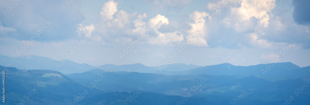 Panorama of blue mountains in spring in the haze