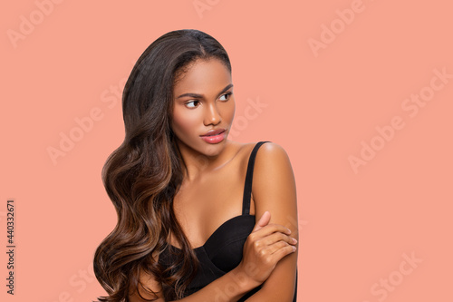 Beauty styled portrait of a young African - American woman. Fashion African - American girl with curly hair posing in the studio over a colored background. isolated. Studio shot.   