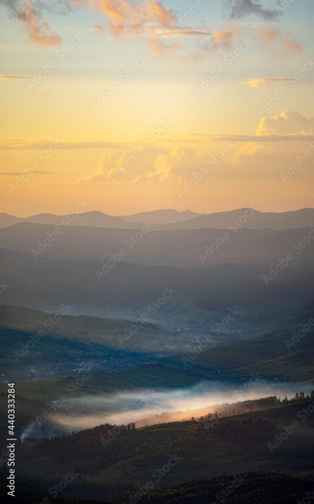 Silhouettes of the Carpathian mountains in the haze at sunset