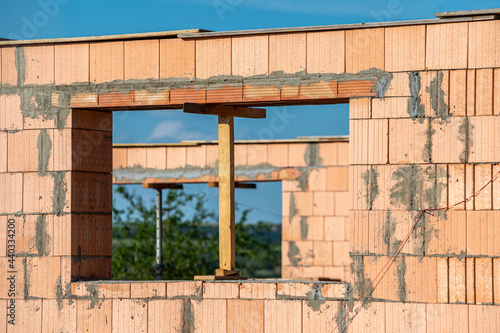 Bau eines Hauses mit Holzstützen in einem neu gemauerten Fenster photo