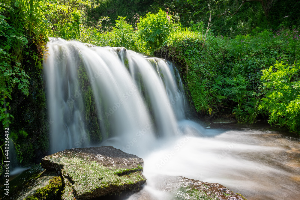 Obraz premium Long exposure of a waterfall flowing onto Lee Abbey Beach in Devon