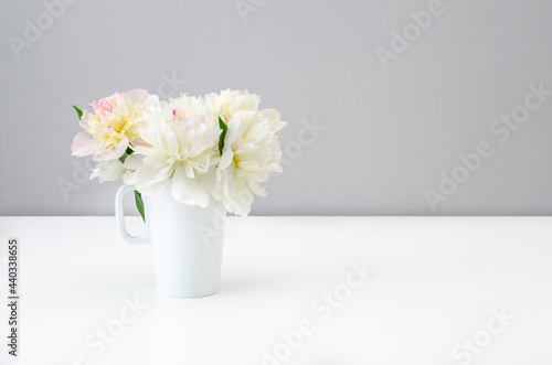 Fototapeta Naklejka Na Ścianę i Meble -  Bouquet of beautiful peonies in a white vase on a white background