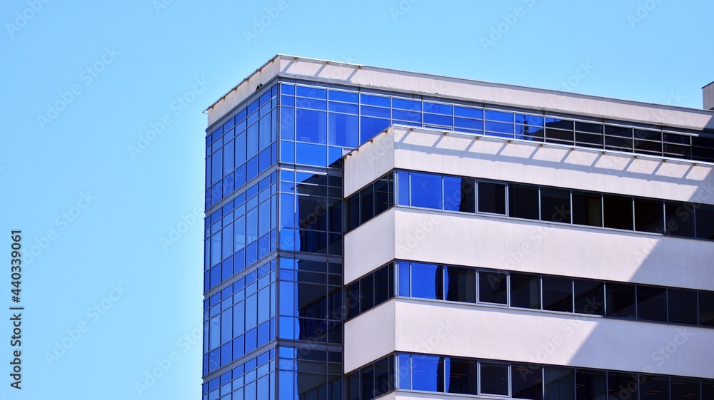 Glass facade of the buildings with a blue sky. Modern building in the business city center. Background of modern glass buildings. Glass facade of the buildings with a blue sky. Modern building in the business city center. Background of modern glass buildings.