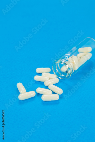 Set of pills on cristal jar for vaccines on coloured background