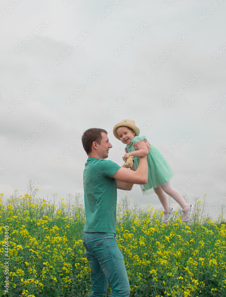 Walking daughter and father in a rapeseed field Walking daughter and father in a rapeseed field