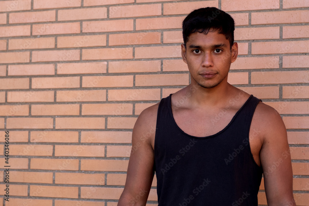 portrait of a serious sportsman of Latino origin wearing a black tank top on the street portrait of a serious sportsman of Latino origin wearing a black tank top on the street