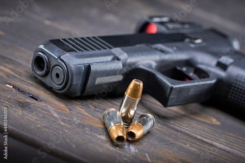 handgun with red dot optic and self-defense bullets photo