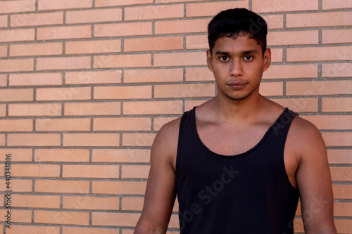 portrait of a serious sportsman of Latino origin wearing a black tank top on the street