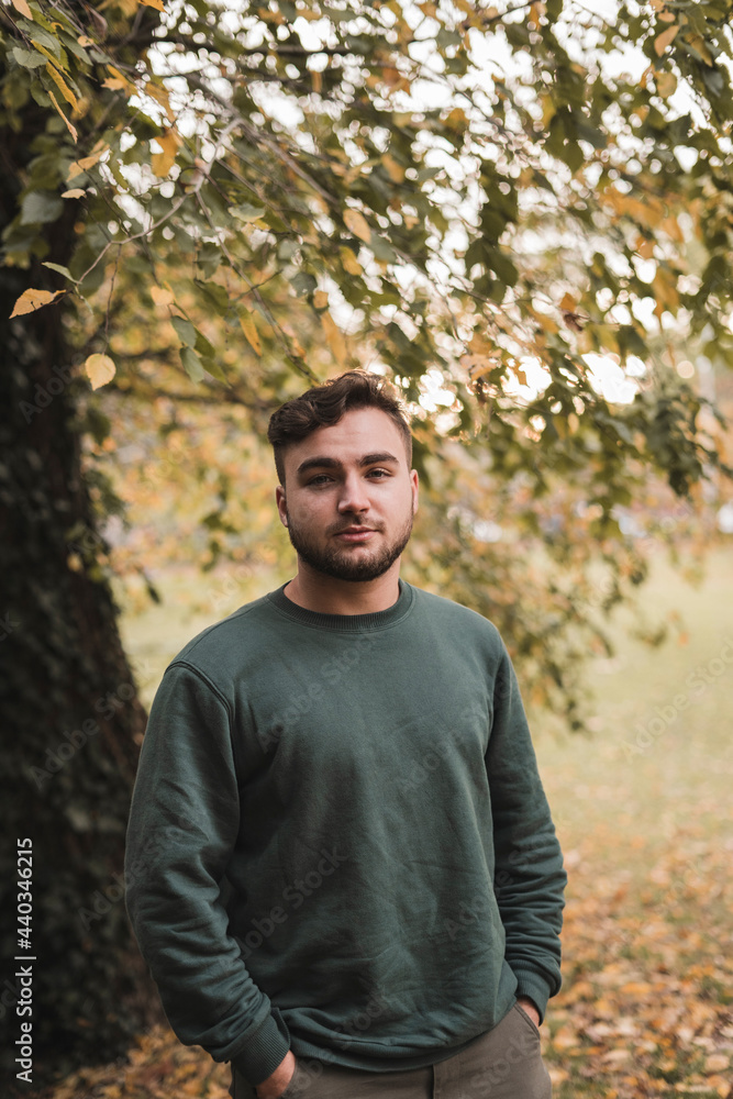 Portrait of a young handsome Caucasian man in a park