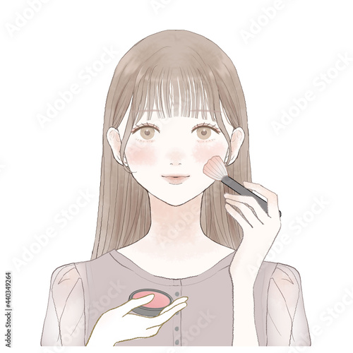 メイクブラシでチークを塗る女性