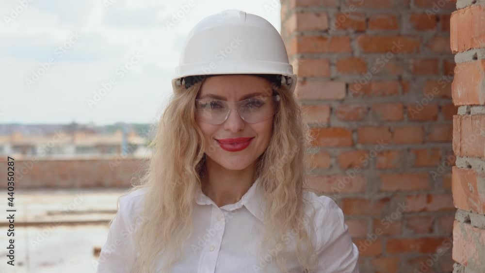 Female architect in business attire stands at the construction site Female architect in business attire stands at the construction site