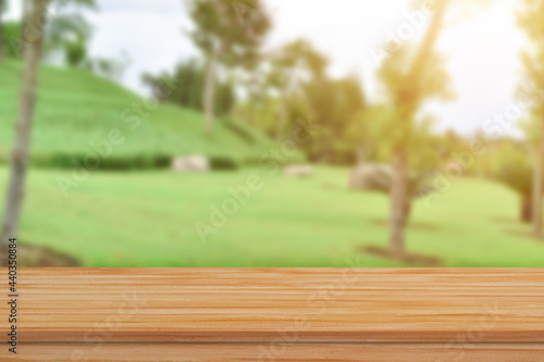 Empty wood table top over blur green nature background for product display or montage.