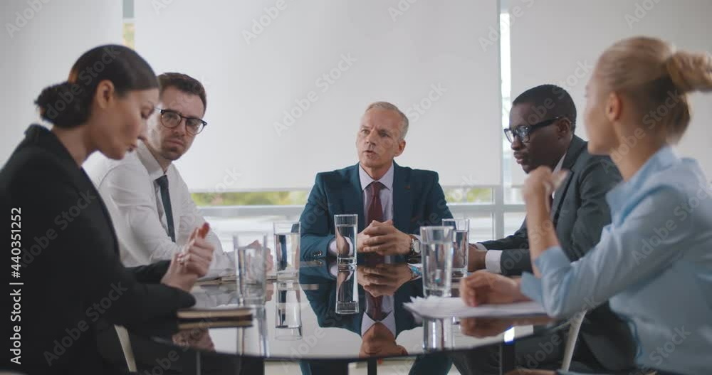 Business leader holding corporate meeting with team in boardroom