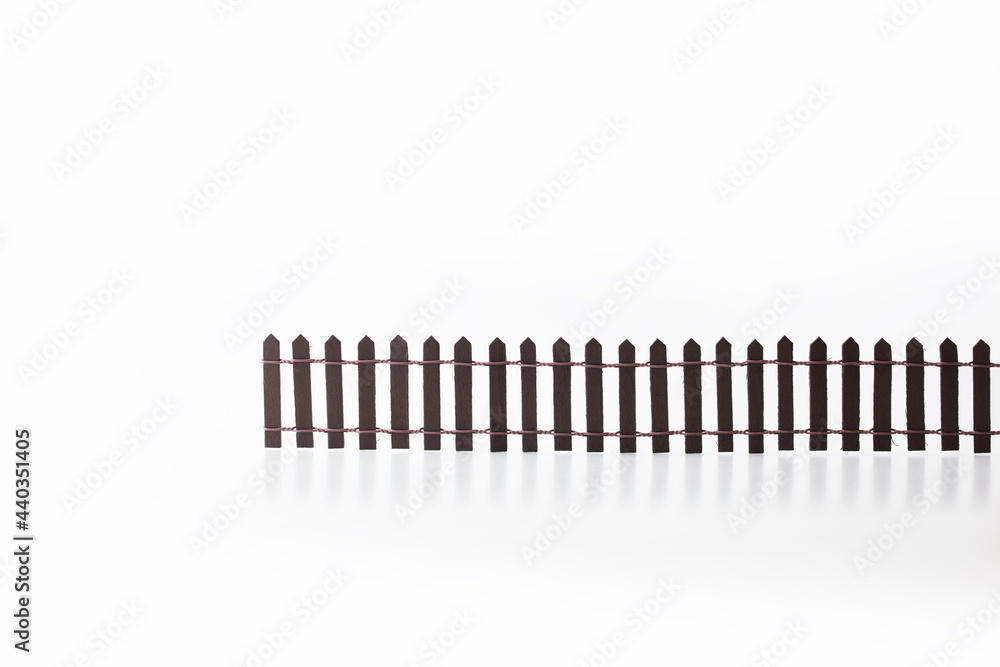 Building wall, fence , or obstacle. Miniature picket fence isolated on white background. Concept image for divides and obstacles. Building wall, fence , or obstacle. Miniature picket fence isolated on white background. Concept image for divides and obstacles.