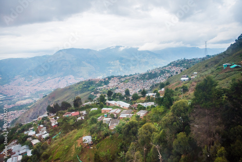 View of houses on hillside with mountains in the background in Medellin, Colombia.