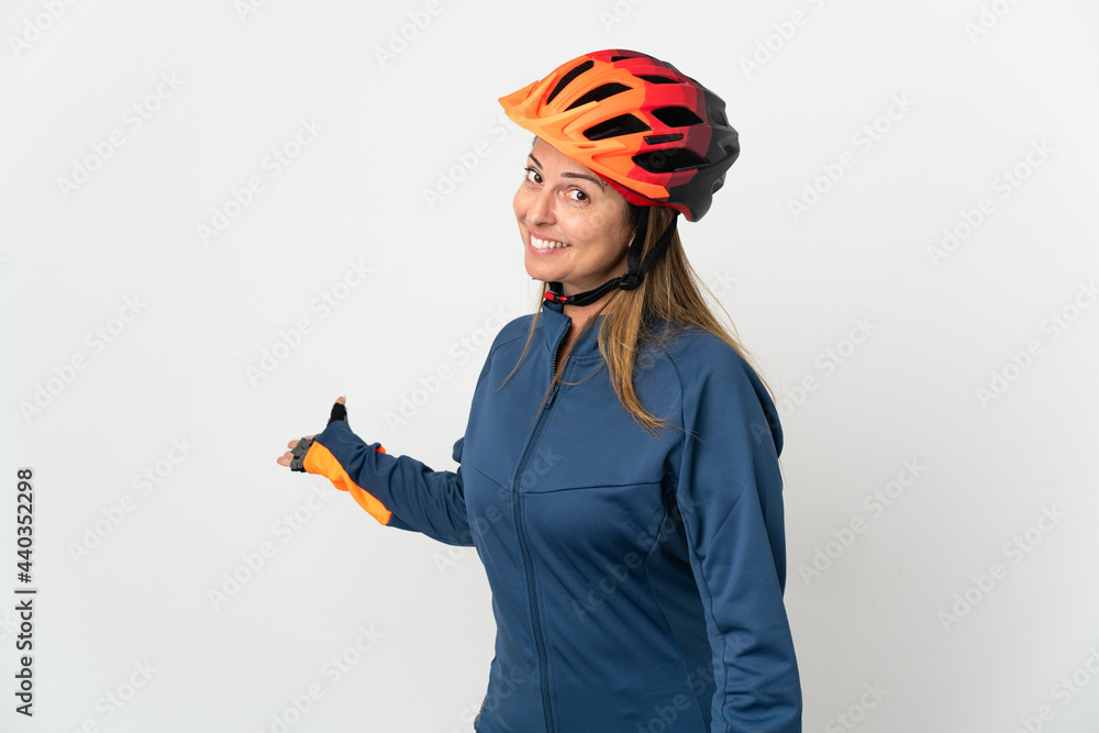 Middle age cyclist woman isolated on white background extending hands to the side for inviting to come Middle age cyclist woman isolated on white background extending hands to the side for inviting to come