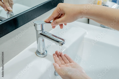 Washing your hands in the sink for cleanliness, rinsing off dirt and preventing the virus.